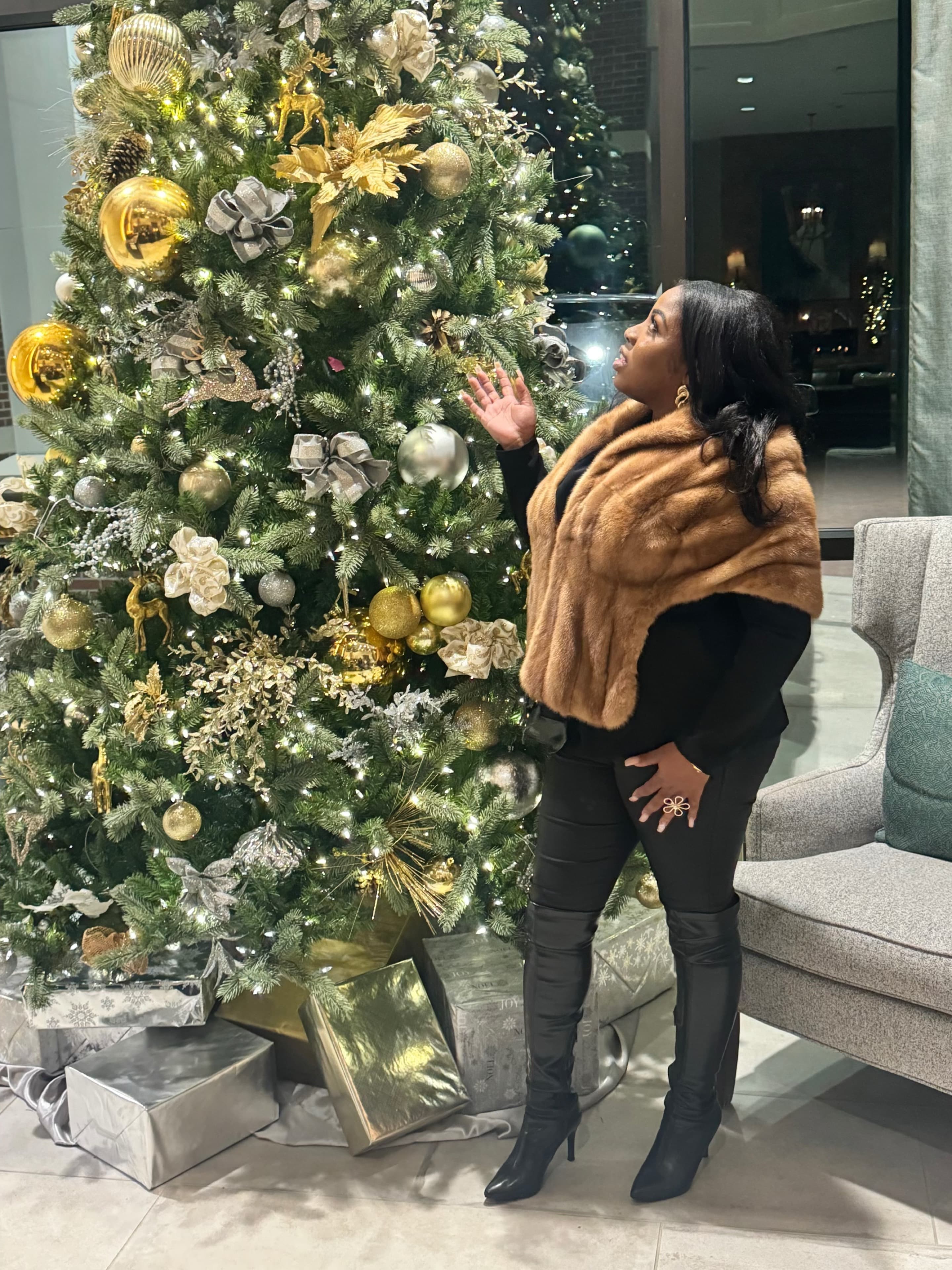 Raneika beside a gold and silver Christmas tree